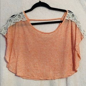 Pink crop top with lace shoulders.